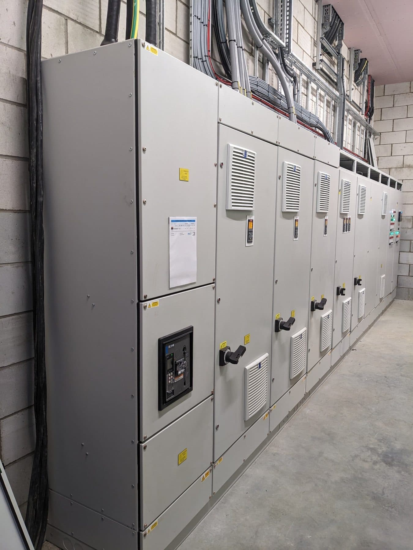 Motor control centre line-up with drive keypads and isolators on the panel doors